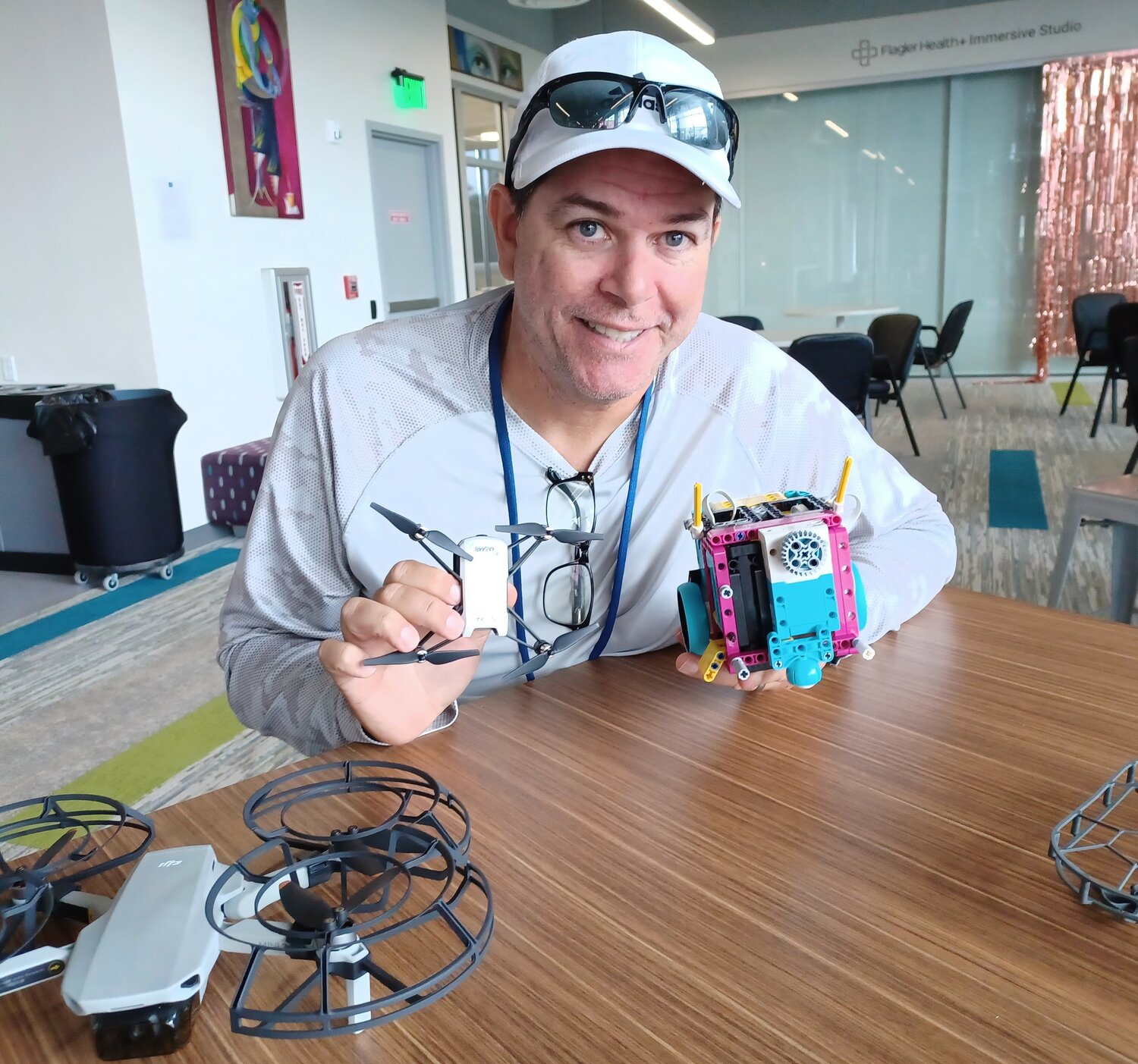 Instructor Ivan Ramirez is seen with some of the Tello drones used in his new classes at the link and a robot from the First LEGO League competition.